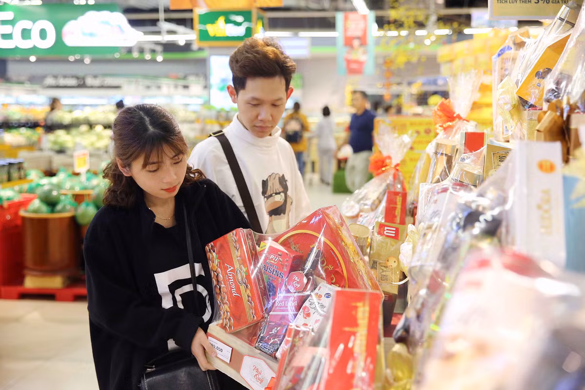 Một đôi vợ chồng trẻ đang lựa chọn giỏ quà Tết phù hợp để biếu gia đình nội ngoại 2 bên. Các loại giỏ quà Tết tại VinMart có giá từ bình dân 199.000 đồng đến cao cấp 2 triệu đồng phong phú chủng loại, từ giỏ quà bánh kẹo truyền thống cho đến các giỏ quà phong thuỷ độc đáo nên thu hút rất nhiều khách hàng.