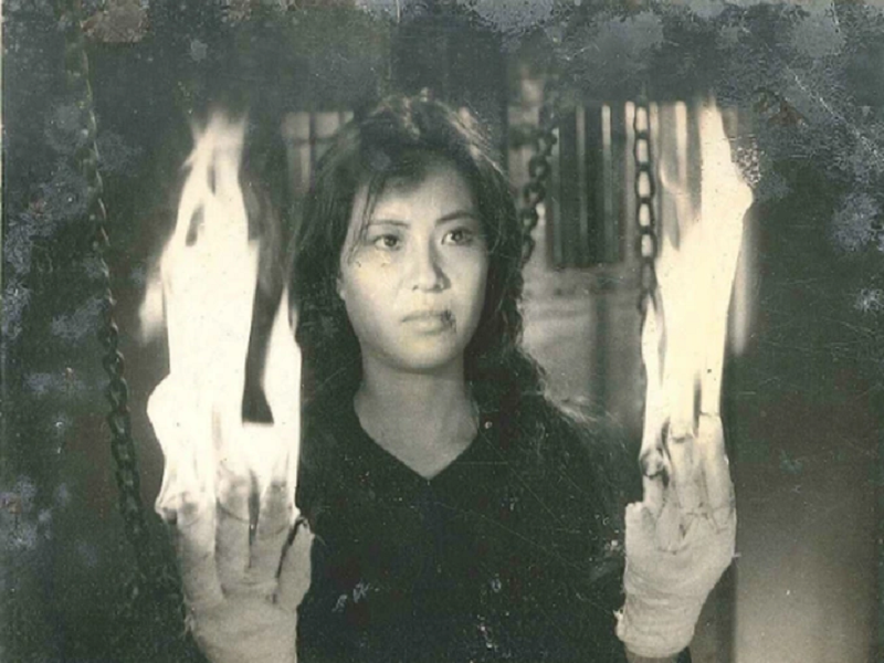 Phân cảnh nhân vật của nghệ sĩ Thụy Vân bị quấn băng gạc tẩm cồn vào 10 đầu ngón tay rồi châm lửa đốt gây ấn tượng mạnh mẽ với người xem. Theo nữ nghệ sĩ, bà không tập dượt mà làm một lần là xong cảnh quay này. Ảnh: Dân Trí