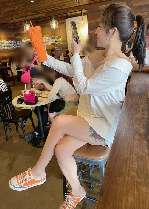 Nữ MC diện mốt giấu quần, để lộ hình xăm khi ngồi.