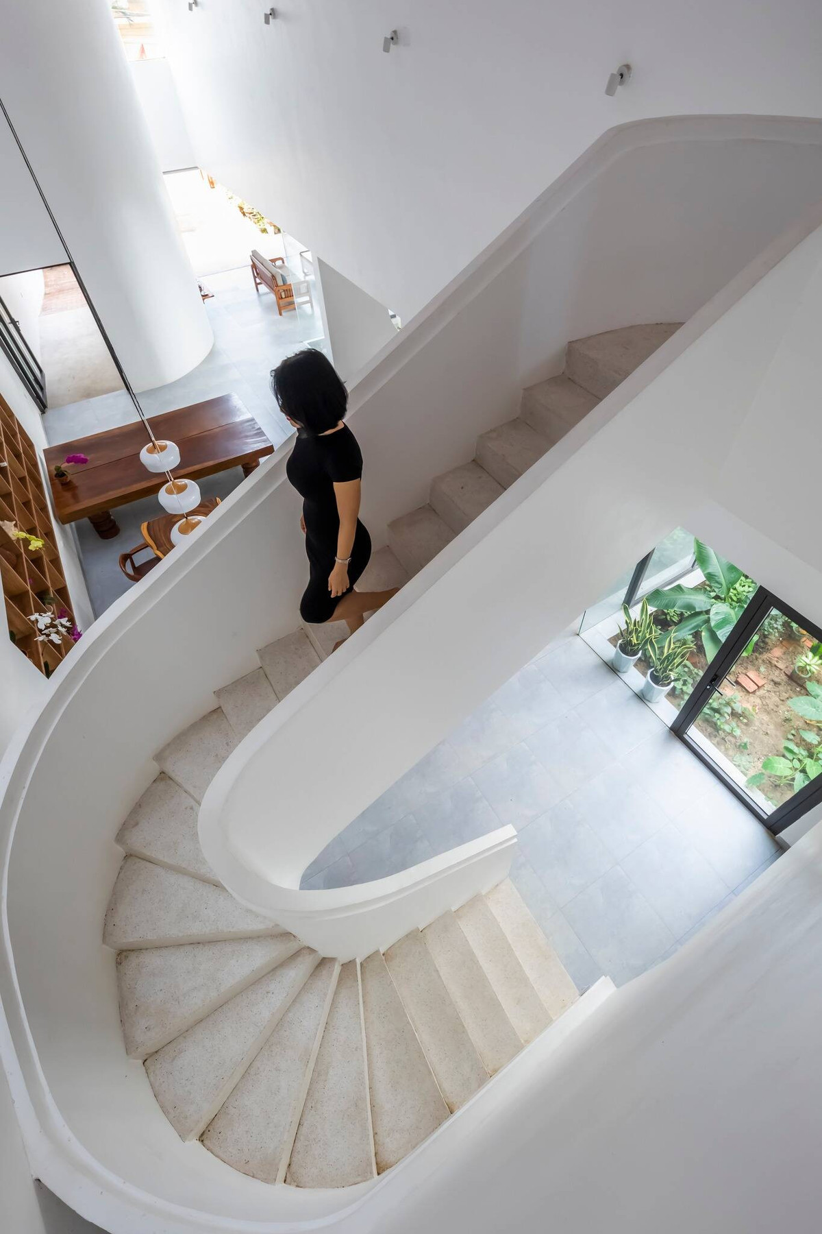 Sau khoảng sân vườn, phòng khách là không gian tiếp theo của ngôi nhà ống. Đây cũng là khoảng đệm ngăn cách giữa phòng khách và gian thờ. Cầu thang dạng xoáy ốc, đẹp và chắc chắn.