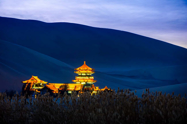 Nhà thờ Mingyue của hồ Nguyệt Nha Tuyền được bao quanh bởi núi Mingsha. Những cồn cát lấn chiếm núi Mingsha luôn đe dọa nhấn chìm ốc đảo mong manh này.