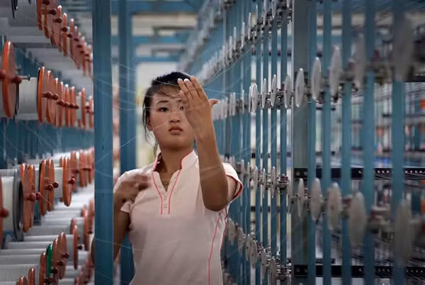 Trong ảnh là một phụ nữ đang làm việc tại nhà máy tháng 7/2014.