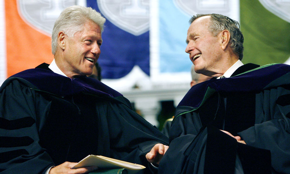 Cựu Tổng thống Mỹ Bill Clinton và George H. W. Bush nhìn nhau cười tươi trên bục giảng tại trường Đại học Tulane ở New Orleans ngày 13/5/2006.