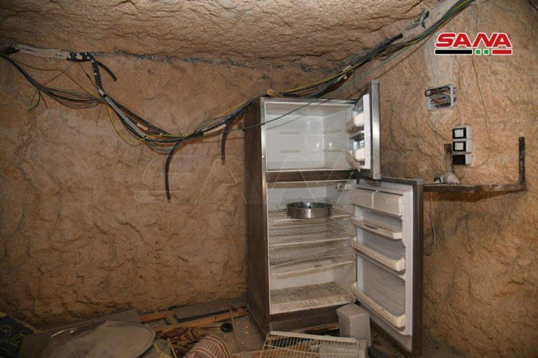 Một chiếc tủ lạnh trống trơn bị bỏ lại trong căn cứ dưới lòng đất của nhóm phiến quân HTS. Ảnh: SANA.