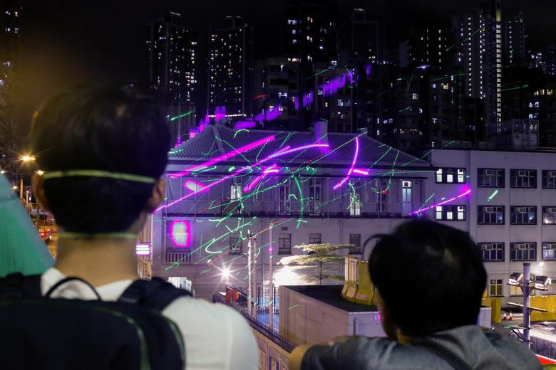 Hãng thông tấn Reuters tiếp tục đăng tải loạt ảnh cập nhật về diễn biến cuộc biểu tình ở Hong Kong. Ảnh: Những người biểu tình phản đối dự luật dẫn độ chiếu tia laser vào đồn cảnh sát ở Sham Shui Po ngày 14/8.