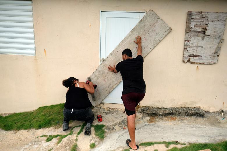 Một cặp đôi gia cố nhà gần bãi biển ở Yabucoa ngày 28/8.