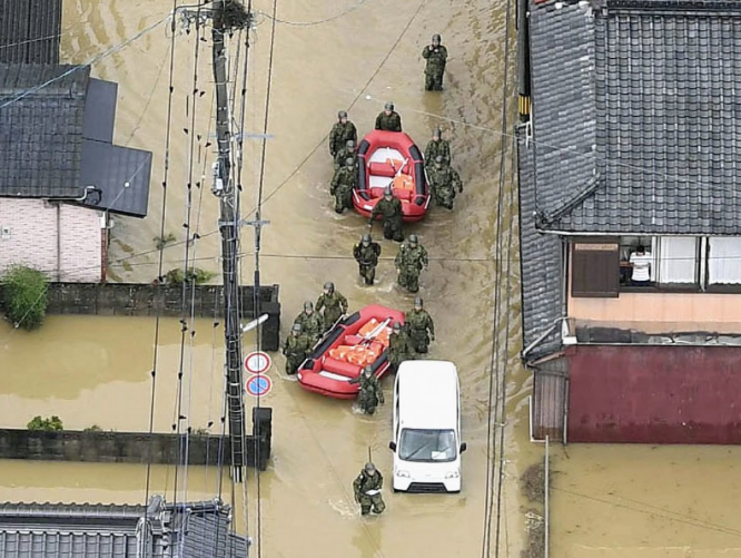 Lực lượng cứu hộ đi giải cứu những người dân mắc kẹt vì mưa lũ.