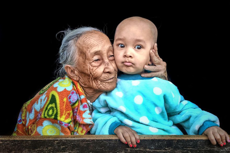 Người bà dành một cái ôm ấm áp đầy yêu thương cho đứa cháu bé bỏng của mình.