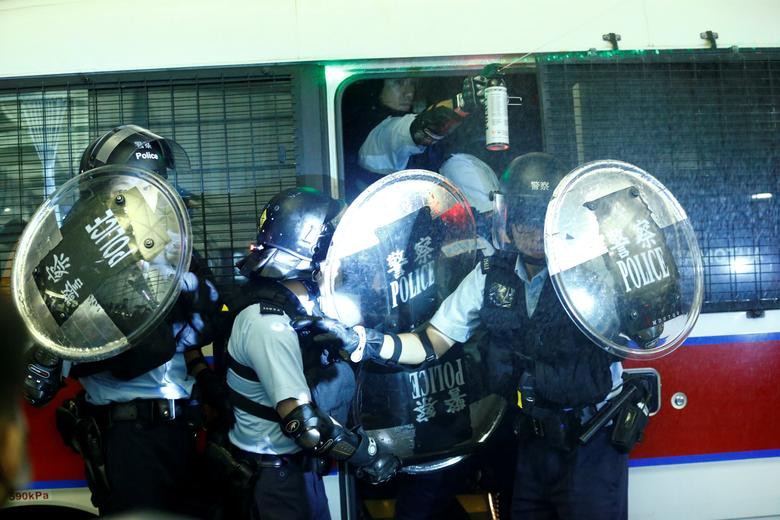 Cảnh sát Hong Kong rút lên một chiếc xe trong cuộc đụng độ tại sân bay ở Hong Kong ngày 13/8.