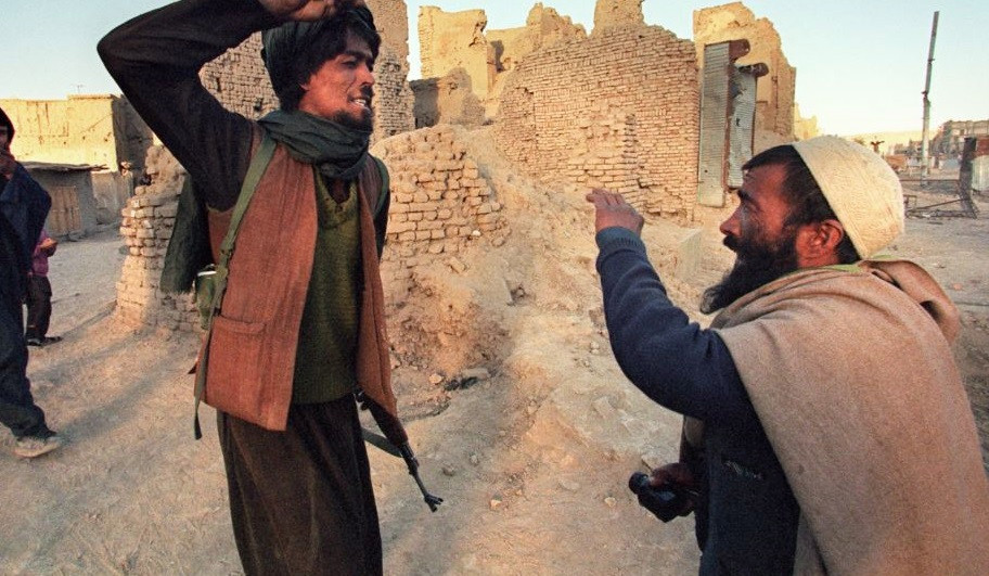 Một thành viên Taliban đánh đập người đàn ông bị bắt khi mang nửa kg thuốc phiện.