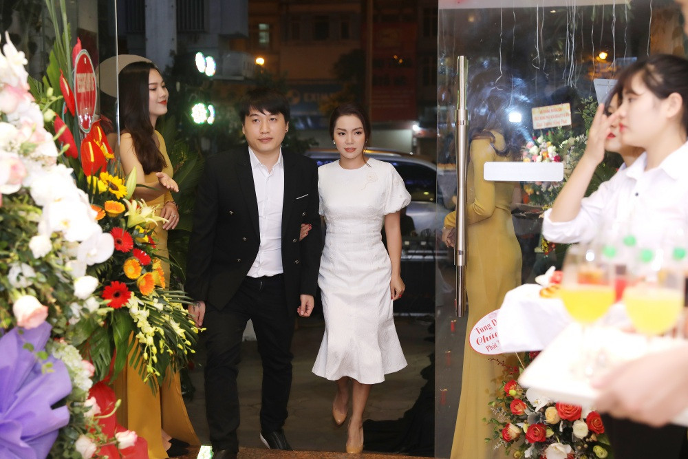 Nữ ca sĩ xinh đẹp hút mắt khi diện đầm trắng tay bồng thanh lịch, nhẹ nhàng. Bạn trai của cô, nam ca sĩ Tô Minh Đức bảnh bao trong bộ vest đen lịch lãm. Nữ ca sĩ được bạn trai chở đi sự kiện trên “xế” sang.