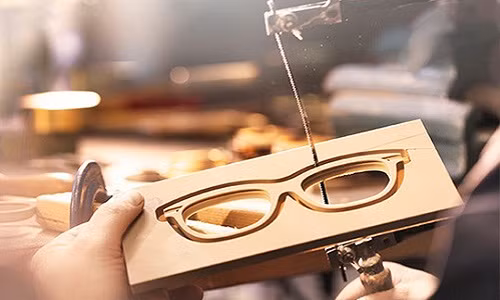 Phần gọng kính được cắt hoàn toàn bằng tay, tách rời ra khỏi bản nhựa.