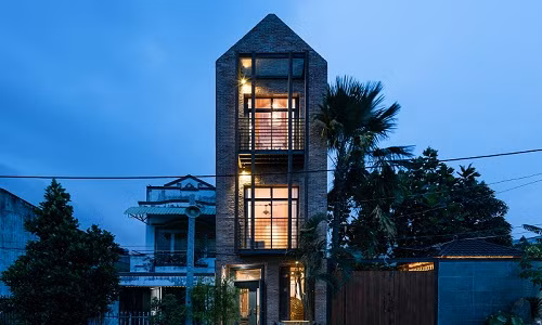 Mặt tiền nhà mộc mạc nhưng cá tính với tường gạch trần và màu nâu gỉ của khung thép.