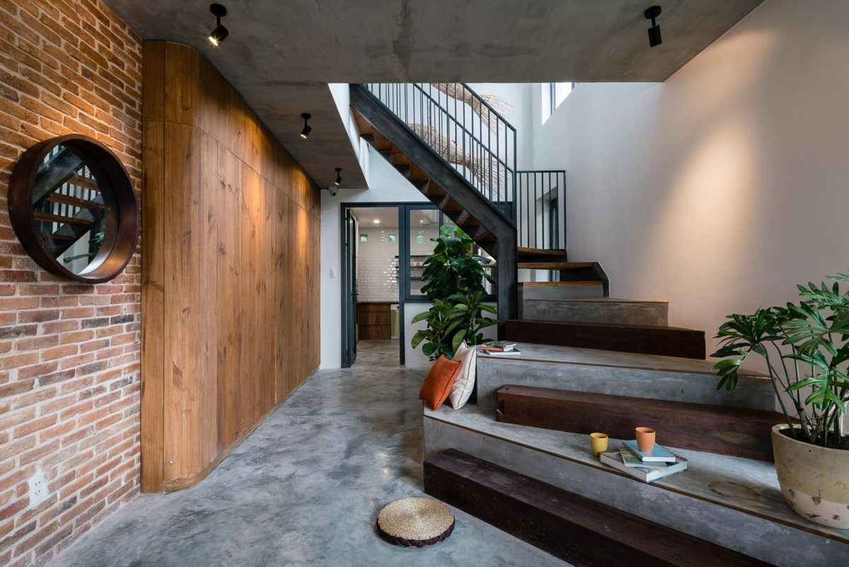 Tay vịn cầu thang được tạo bởi hệ khung thép. Ô lấy sáng được mở thêm trên tường.