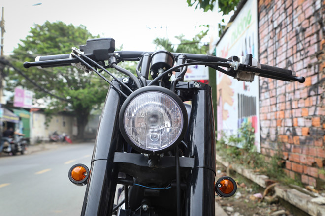 Đèn pha dạng tròn cổ điển sử dụng bóng halogen được thay mới, nhỏ gọn hơn so với đèn nguyên bản. Bên cạnh đó, đèn xi-nhan hình quả nhót cũng khiến đầu xe trở nên gọn gàng hơn, để lộ rõ phần phuộc ống lồng kích thước lớn.