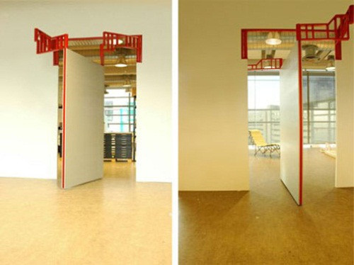 Cửa "bức tường" không sử dụng bản lề dọc trên một trục thẳng đứng mà sử dụng bản lề ngang có cánh tay đòn đặt trên cao cùng với hệ thống trụ xoay tròn.