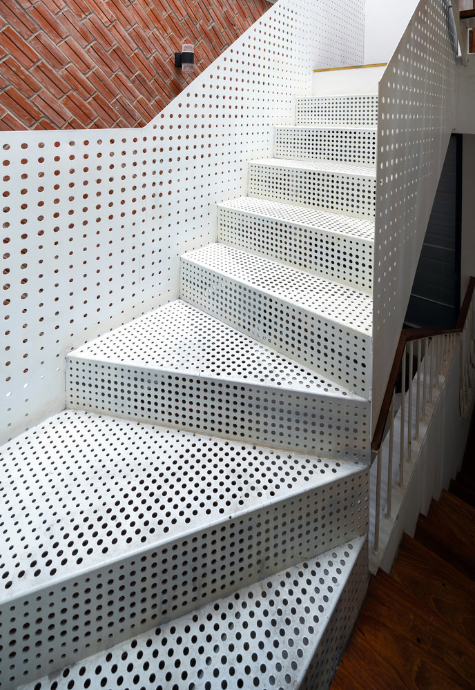 Chất liệu thép lỗ cùng bậc gỗ mở ở cầu thang tạo sự mới lạ đồng thời đảm bảo sự thông thoáng giữa các tầng.