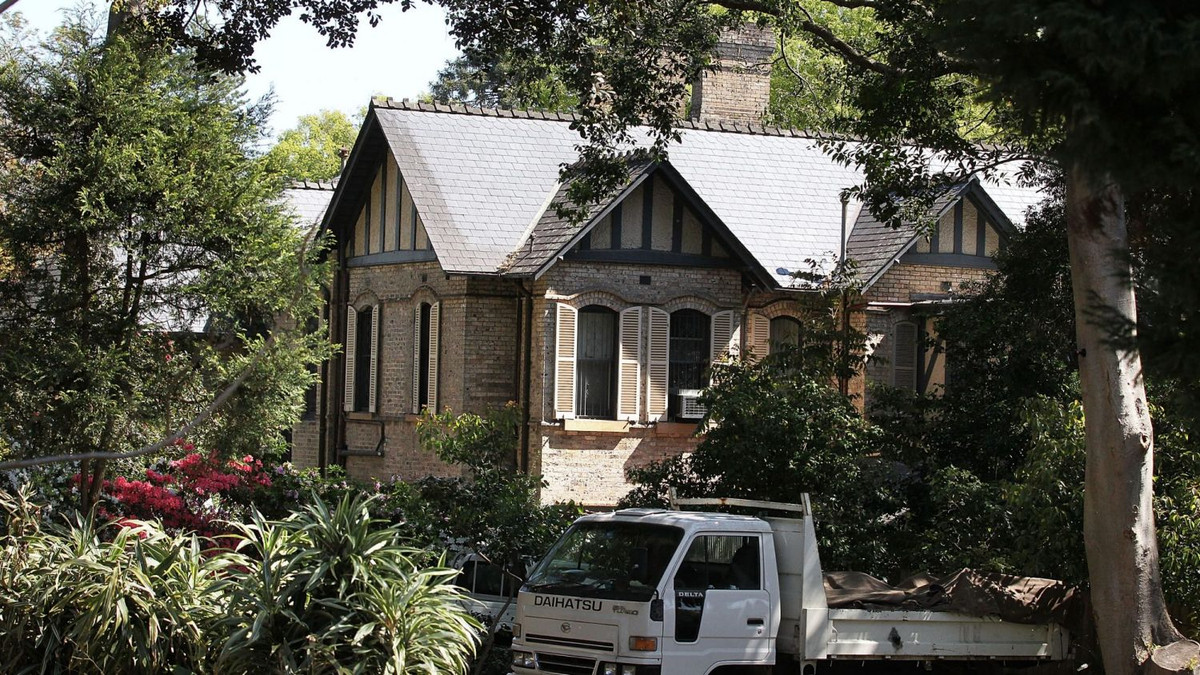  Biệt thự 2 tầng xây bằng gạch màu vàng nhạt, có mái lợp bằng đá phiến.