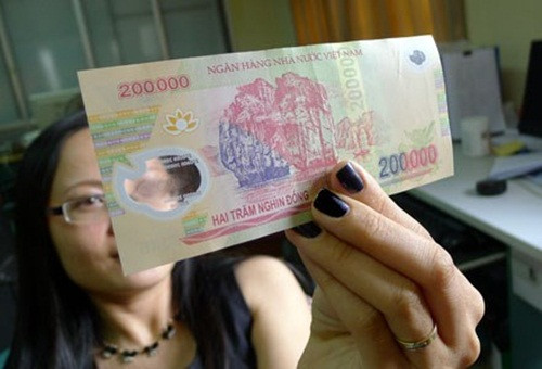 Trong khi đó ở tiền giả, cụm số mệnh giá dập nổi trên cửa sổ lớn không tinh xảo như tiền thật, trong cửa sổ nhỏ không có hình ẩn.