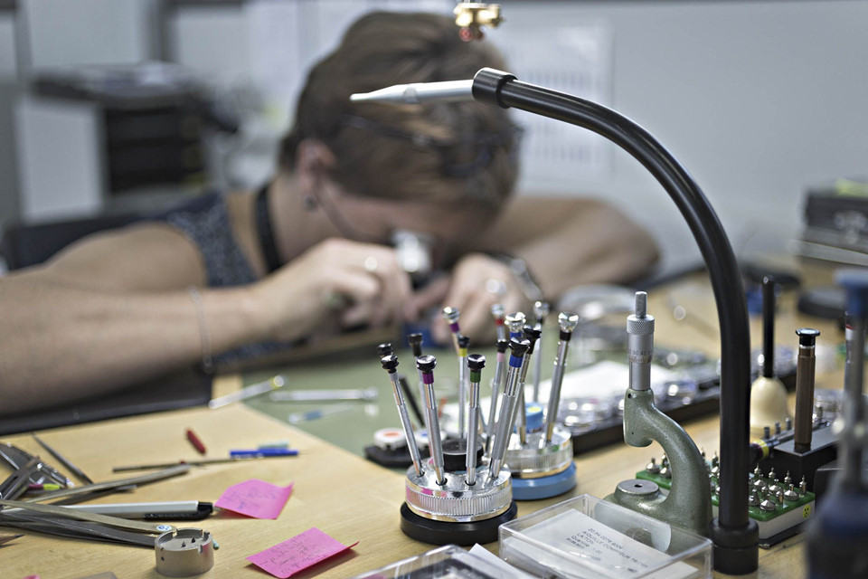 Kim đồng hồ và bánh xe cân bằng được nhân viên lắp ráp bằng tay, sử dụng các ống kính cực nhỏ trong không gian làm việc vô trùng.