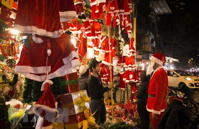 Các sản phẩm trang trí Noel năm nay khá đa dạng về mẫu mã và kiểu dáng như: bóng treo, ông già Noel, quần áo...Ảnh: TTXVN.