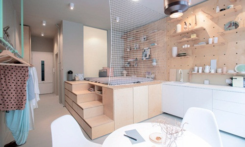 Bức tường trên gường ngủ và bàn bếp trong căn hộ được phủ tấm bảng đục lỗ treo tường lạ mắt.