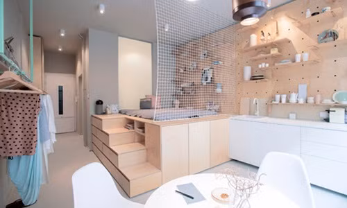 Bức tường trên gường ngủ và bàn bếp trong căn hộ được phủ tấm bảng đục lỗ treo tường lạ mắt.