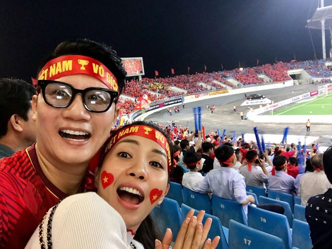 Hoàng Bách và vợ bay từ Tp.HCM ra Hà Nội để trực tiếp ra sân cổ vũ đội tuyển Việt Nam. Trước đó anh cũng từ chối show diễn, bay ra thủ đô cổ vũ trận đội tuyển nước nhà gặp Malaysia ở bảng A.