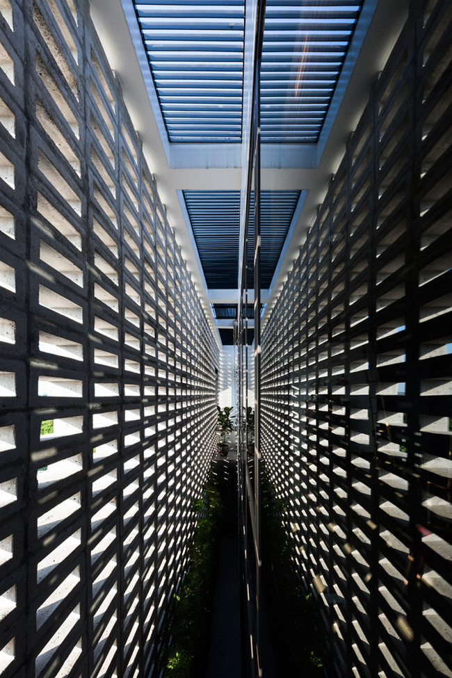 Để hạn chế nhược điểm bị ánh nắng xiên vào, kiến trúc sư thiết kế tường 2 lớp đặc biệt. Lớp ngoài là tường rỗng, nhiều lỗ thủng, lớp trong là tường kính chắn bụi, chắn gió vào mùa đông.