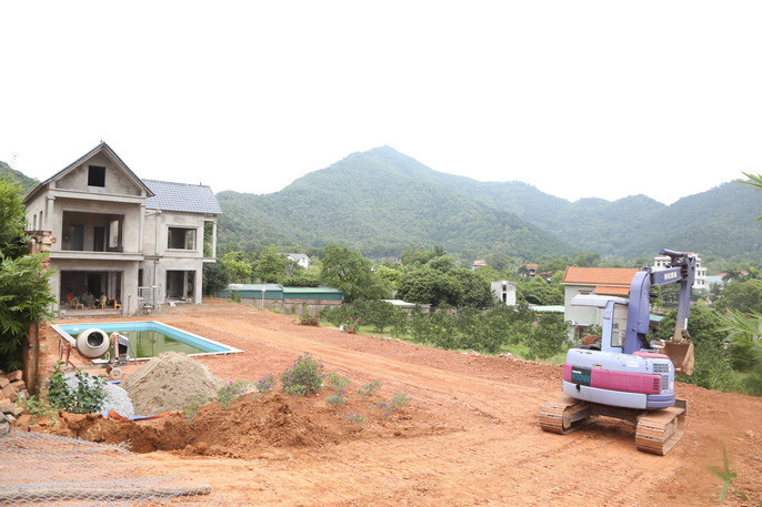 Máy xúc, máy ủi phục vụ công tác san lấp mặt bằng. Ảnh: Nld.