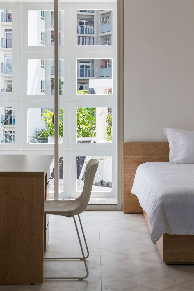 Phòng ngủ kết hợp góc làm việc ngập ánh sáng.