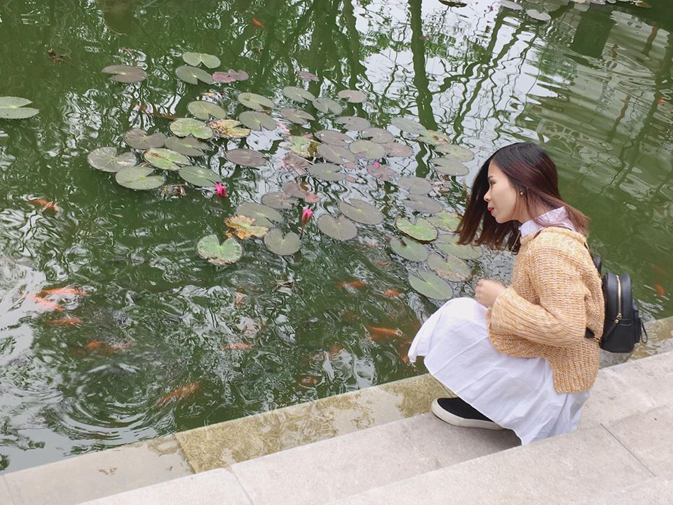 Ẩn nấp giữa những lùm cây là ao sen nhỏ với một chiếc cầu đá cổ, bông sen hồng khoe sắc. Ảnh: Dân Việt.