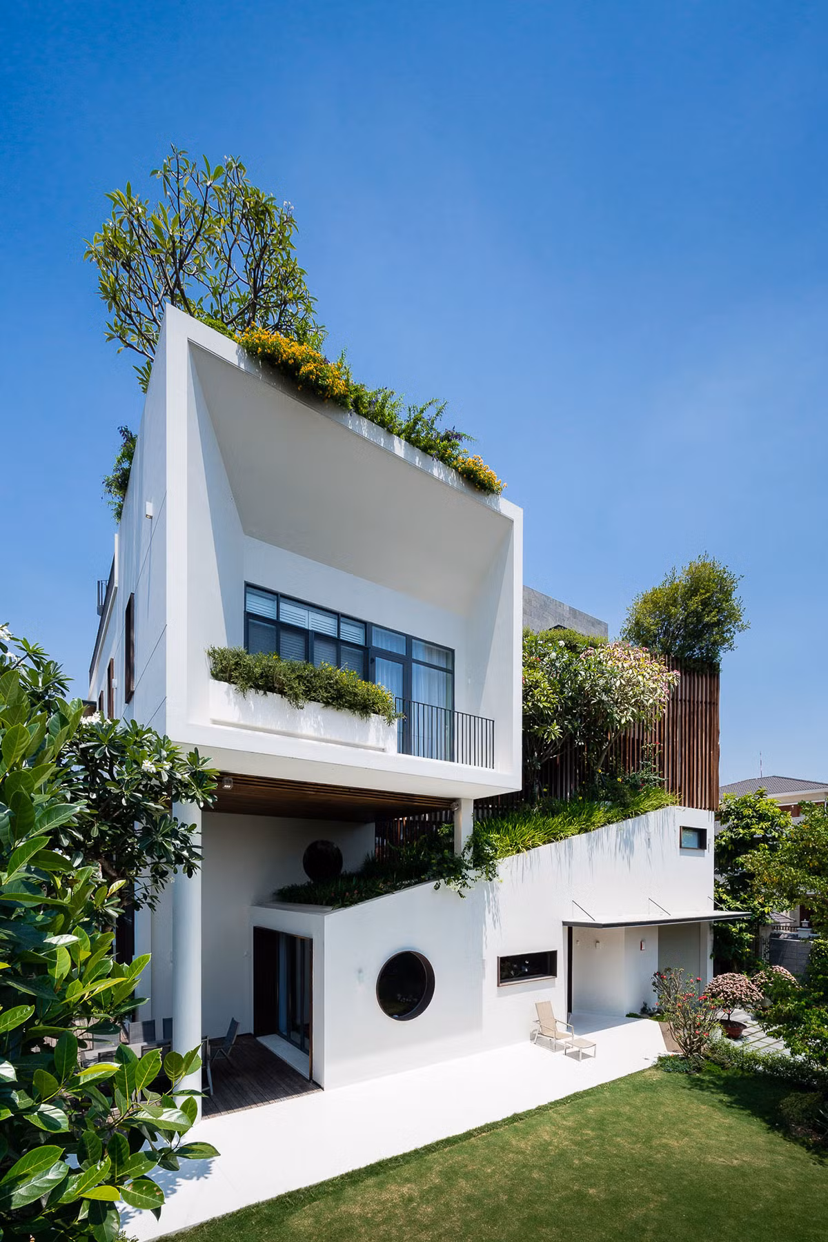 Căn biệt thự với gam màu trắng tinh tế, đan xen bởi những hàng cây xanh ngắt là công trình thiết kế của nhóm QBI studio.