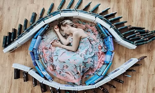 Sử dụng Instagram từ năm 2016, ban đầu Elizabeth chỉ chụp mỗi bìa sách. Tuy nhiên, khi nảy ra ý tưởng cho bản thân xuất hiện trong khung hình, cô đầu tư kỹ lưỡng hơn về chủ đề của bức ảnh, chọn màu sắc và cách xếp sách thích hợp. Bức ảnh này khiến người xem liên tưởng ngay đến một con mắt đang mở to.