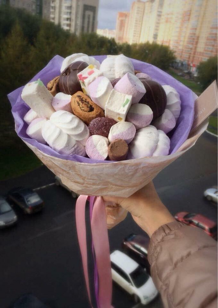 Bên cạnh hoa tươi, nhiều cửa hàng còn giới thiệu đến sản phẩm hoa tươi kết hợp cùng trái cây, bánh, kẹo được nhiều người lựa chọn. Ảnh: Phunuvietnam.