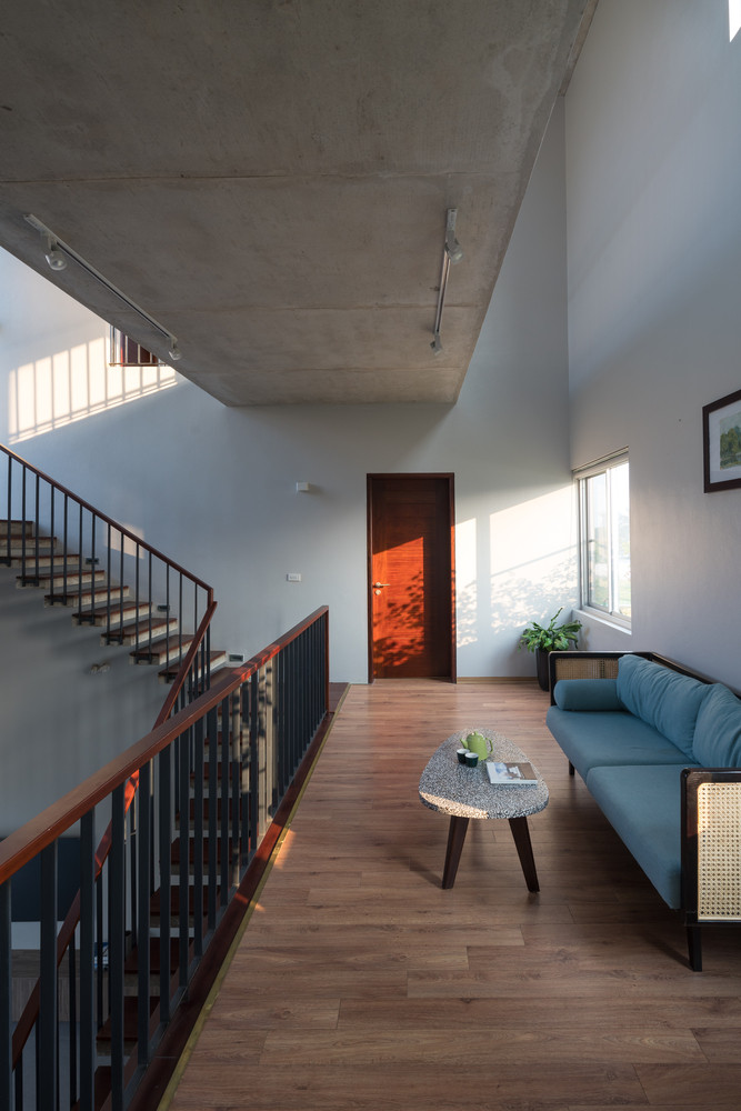 Không gian nội thất thiết kế tối giản với các bức tường trát xi măng, trần bê tông thô.