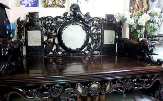 Sập có nguồn gốc từ Trung Quốc, được làm nguyên miếng bằng gỗ lệ chi, chạm khắc rất tinh xảo với hình con rồng đang ôm quả địa cầu. Ảnh: Zing.