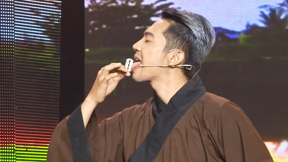 Trong tiểu phẩm "Tìm về", Mai Quốc Việt vào vai người chồng của Quỳnh Chi, chuyên sống bằng nghề sơn đông mãi võ. Để có tiền, anh không chỉ biểu diễn khả năng bịt mắt phóng dao mà còn nhai lưỡi lam thật.