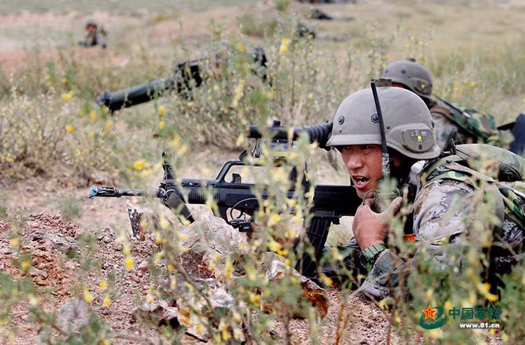 Trong ảnh là một binh sĩ Trung Quốc sử dụng bộ đàm gọi hỗ trợ hỏa lực từ trên không từ những chiếc Z-10.