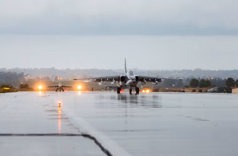 Hình ảnh những chiếc máy bay Su-25 nối đuôi nhau chuẩn bị rời khỏi căn cứ không quân Hmeymin dưới cơn mưa tầm tã.