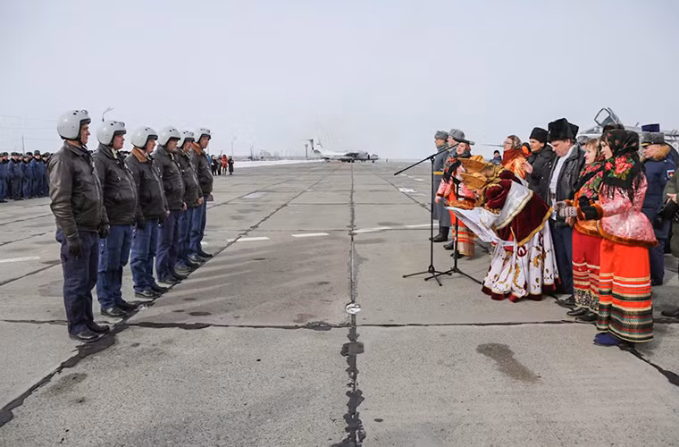 Các phi công Su-24M được đón tiếp bằng phong tục truyền thống của Lực lượng Không quân Nga trước khi báo cáo hoàn thành nhiệm vụ tại Syria. Nguồn ảnh: BQP Nga