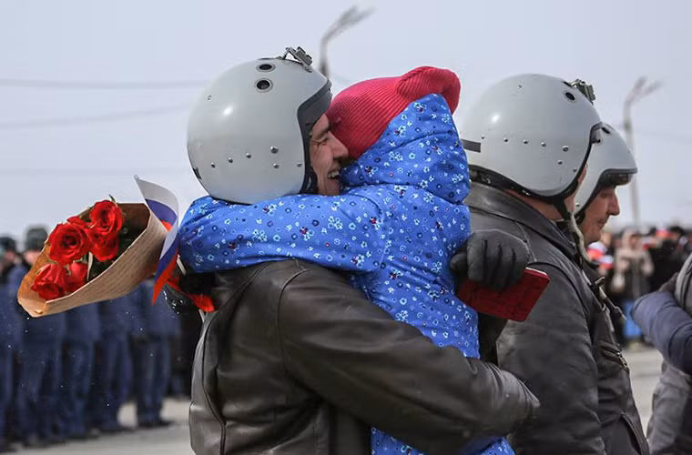 Một phi công Su-24M ôm chằm lấy con gái của mình sau khi buổi lễ kết thúc. Nguồn ảnh: BQP Nga