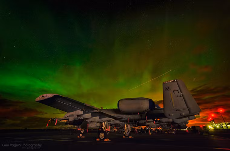 Trong ảnh là một chiếc cường kích A-10 của Không quân Mỹ dưới bầu trời đêm đang xảy ra hiện tượng cực quang huyền ảo.