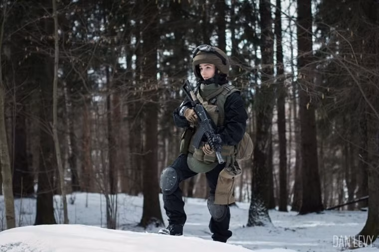 Gương mặt xinh xắn của cô dường như lấn án sự lạnh lùng của bộ quân phục và khẩu súng trường trong tay.