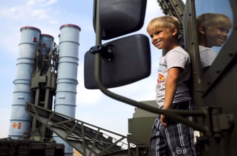 Một khán giả nhí đứng bên cạnh tổ hợp S-300 tại thao trường Ashuluk nơi diễn ra phần thi giữa bốn đội gồm Nga, Kazakhstan, Belarus và Trung Quốc.