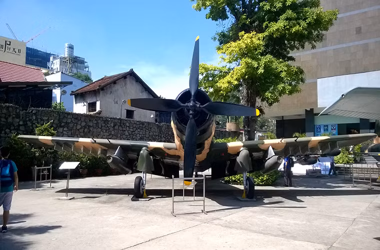 Nằm cạnh chiếc F-5E là một chiếc cường kích A-1 Skyraider, nó và F-5E là dòng máy bay chiến đấu chính được Đế quốc Mỹ viện trợ cho VNCH trước đây.