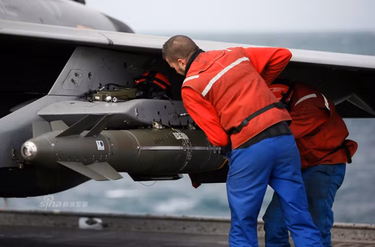 Các nhân viên hỗ trợ kỹ thuật trên tàu sân bay Charles de Gaulle gắn tên lửa không đối đất AASM lên trên một chiếc Rafale M trước khi nó xuất kích.