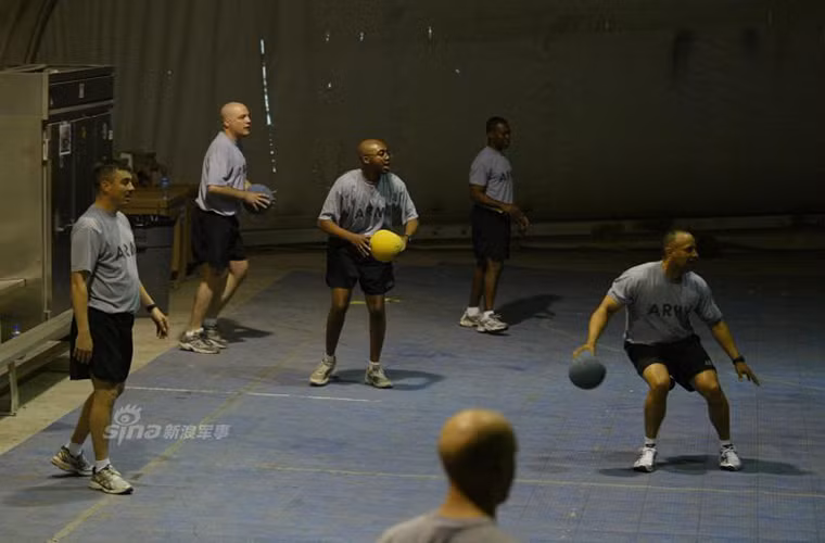 Một nhóm binh sĩ Mỹ chơi bóng ném bên trong một khu thể thao trong nhà.