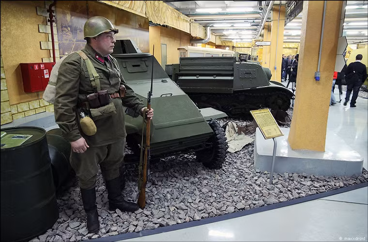 Hình ảnh một tình nguyện viên đóng vai chiến sĩ Hồng quân bên cạnh các thiết bị quân sự bên trong Bảo tàng Chiến tranh vệ quốc vĩ đại.
