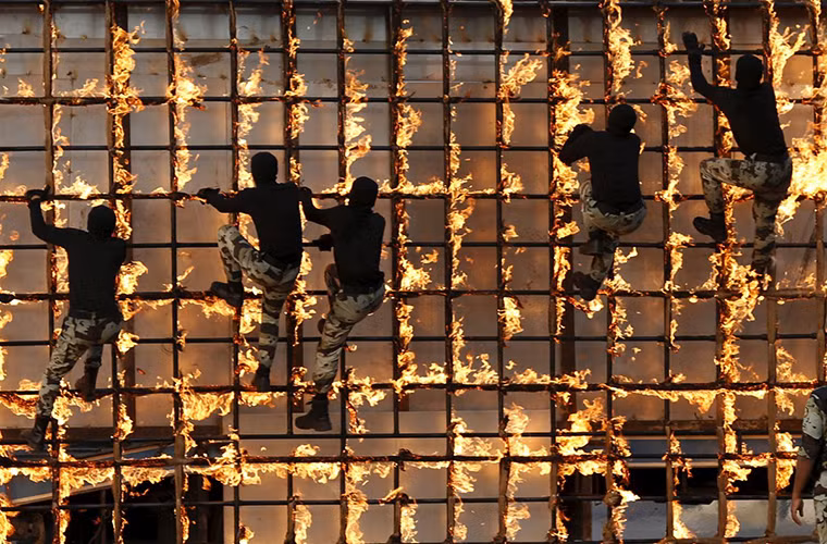 Trong ảnh là các binh sĩ thuộc lực lượng đặc nhiệm Ả Rập Xê-út trong màn trình diễn trèo qua hàng rào lửa.
